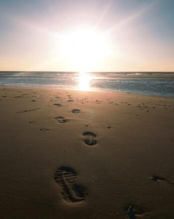 Footprints on the empty sand, illustrating the need for a quiet space to be alone with God.