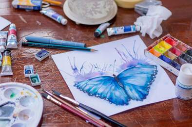 Artist’s materials and painting of a butterfly, illustrating the idea that we were created to worship in different ways.