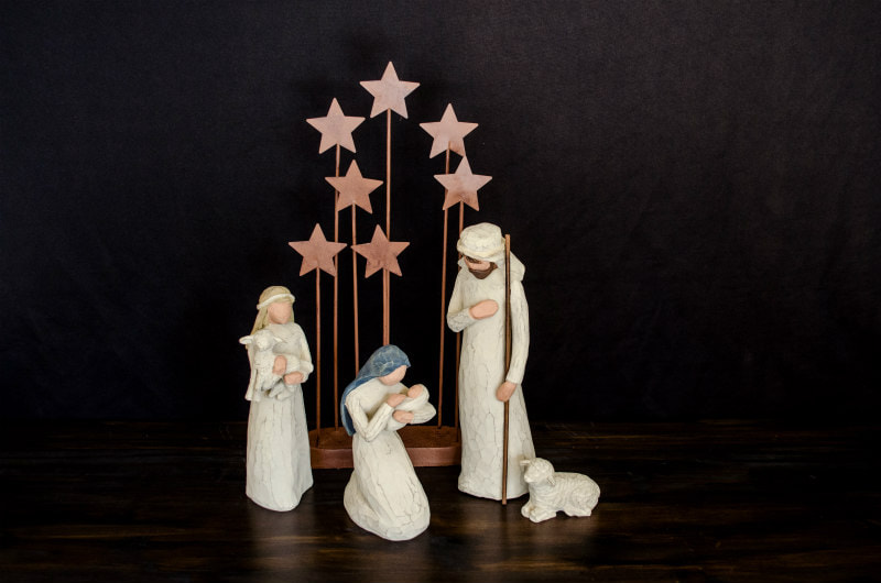 Nativity scene with models of Mary & the baby, Joseph and a shepherd with sheep, against model stars.