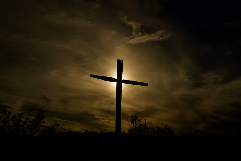 Illuminated cross showing against a dark sky.