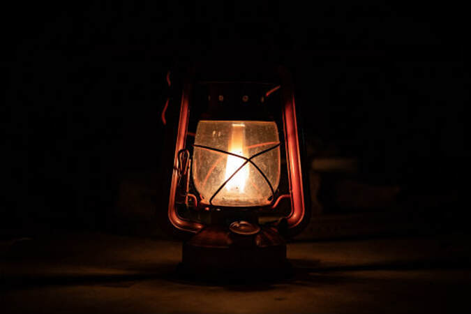 Hurricane lamp glowing in the darkness.