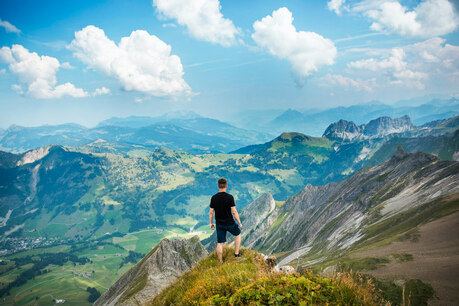 Man looking at glorious mountain scene, illustrating the world is filled with the glory of the Lord.