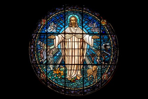 Stained glass window of risen Christ, illustrating ‘Jesus, the manifest presence’.