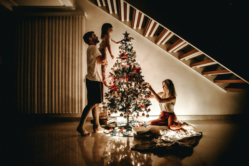 Family dressing a Christmas tree.