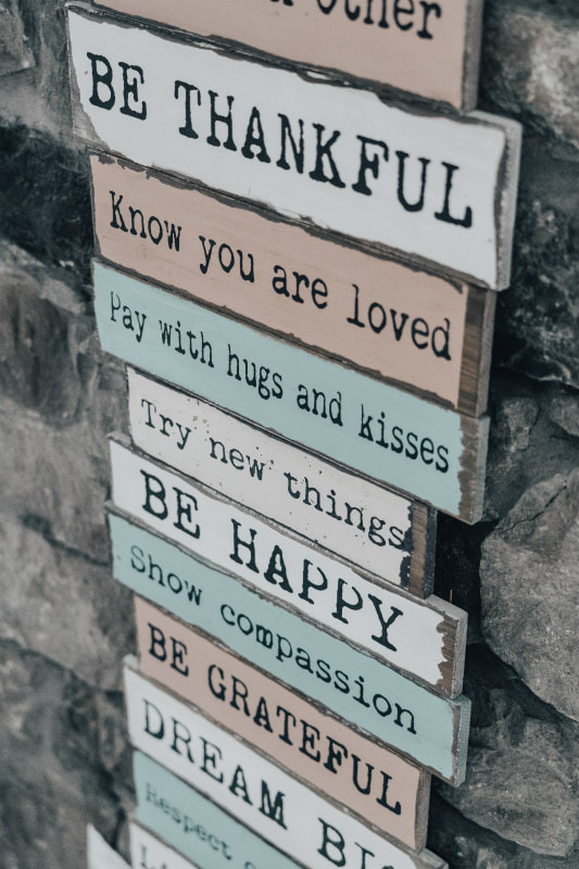 A variety of 'commands' like, 'Be grateful' emblazoned on wooden boards.