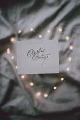 A card with 'Christmas Greetings', surrounded by lights.