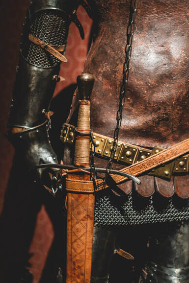Close-up of man in armour, carrying a sword, illustrating section on weapons of spiritual warfare.