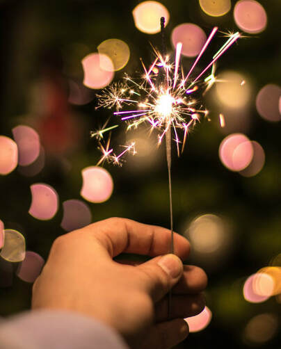 Close-up of a hand holding an indoor sparkler.