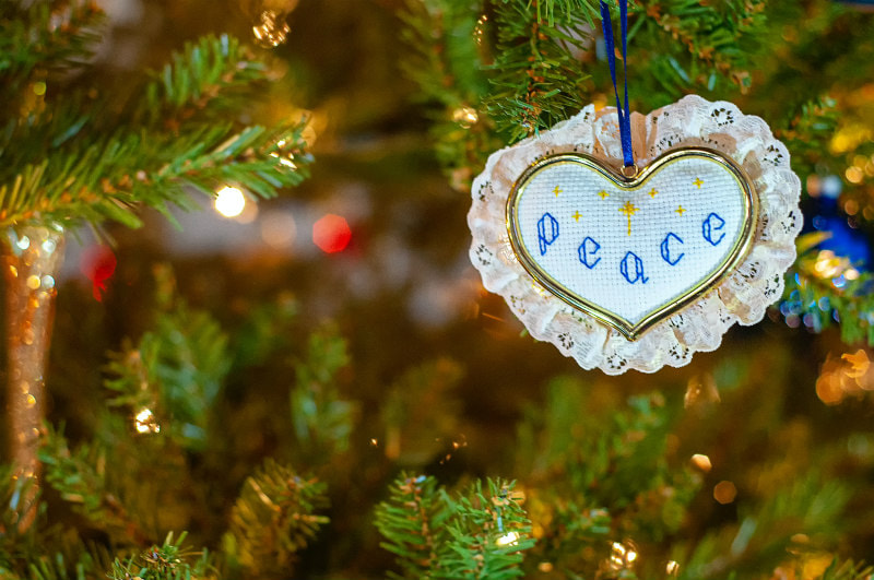 Christmas tree decoration with 'peace' embroidered on it.